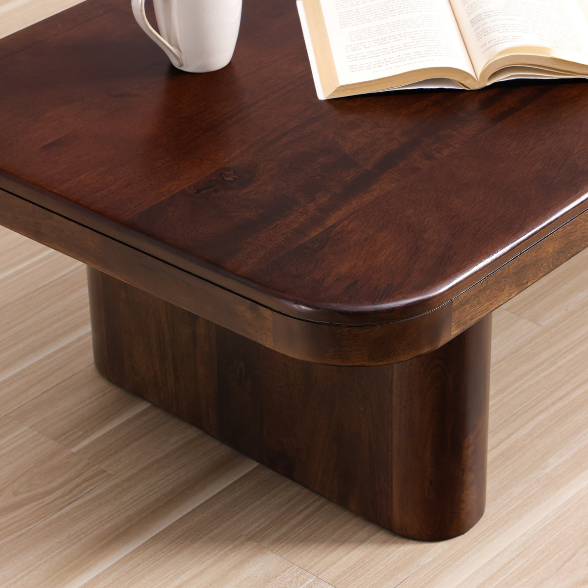 Close-up of the Cinder coffee table corner, showing the thick rounded top and a slab leg