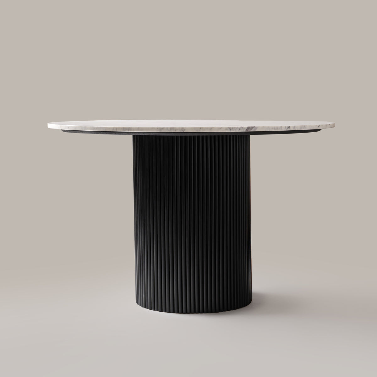 Kelby round natural marble dining table with black reeded pedestal, front view