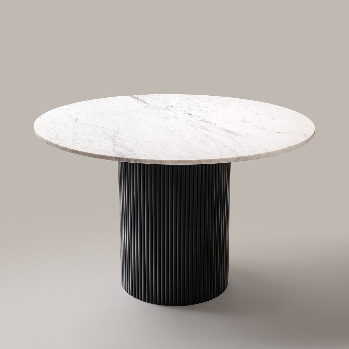 Kelby round marble dining table with black base, angled view