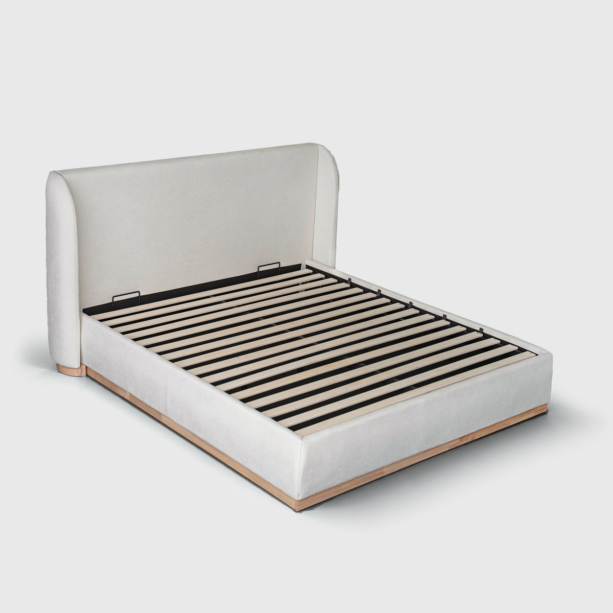 Bora Bed with Gaslift Storage in cream fabric, three-quarter view with wingback headboard and timber plinth