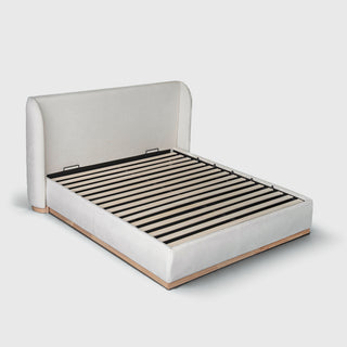 Bora Bed with Gaslift Storage in cream fabric, three-quarter view with wingback headboard and timber plinth
