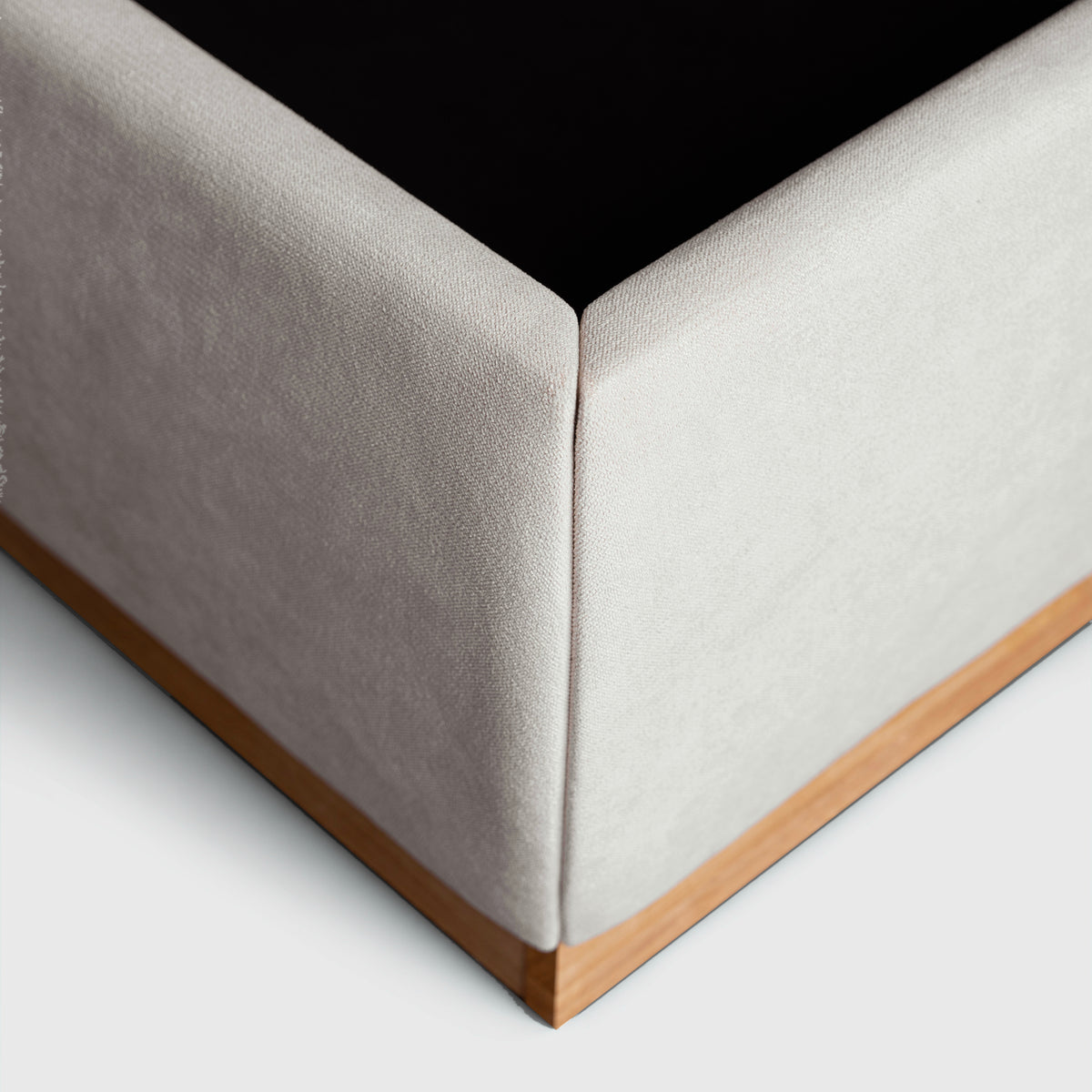 Bora Bed close-up of upholstered corner and natural timber plinth