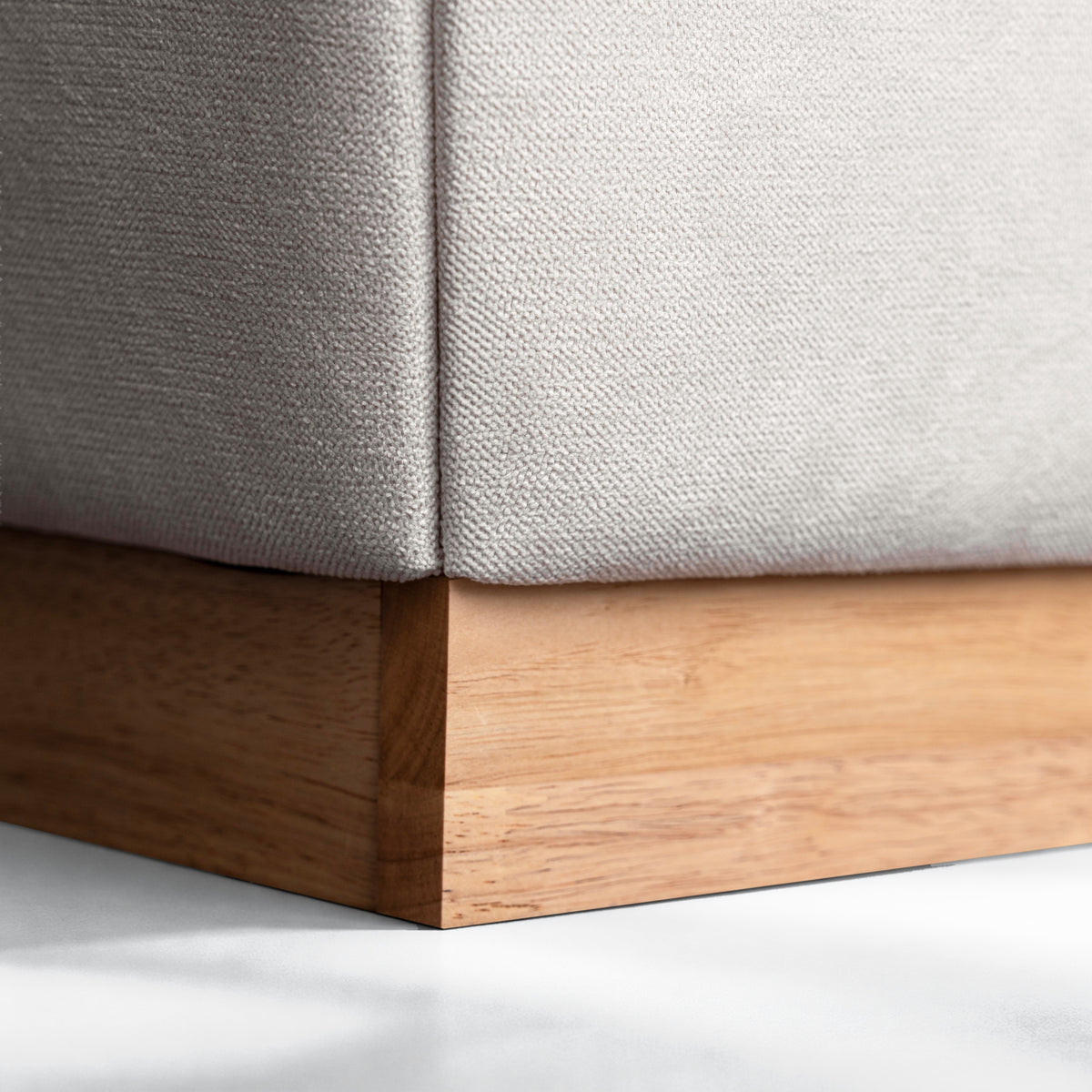 Bora Bed close-up of natural timber base and cream fabric