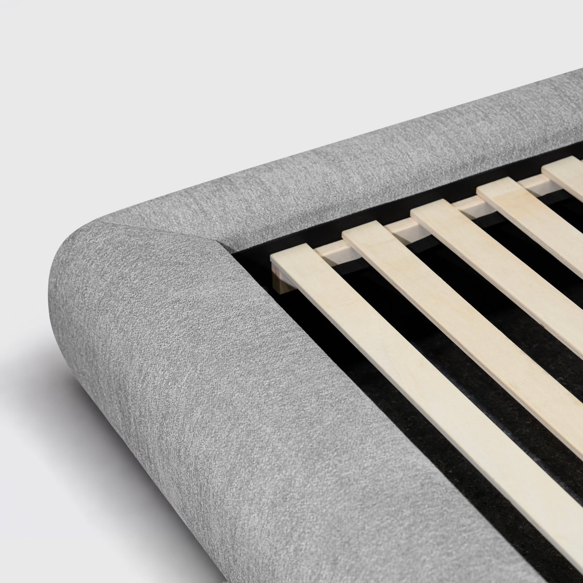 Haze Bed close-up of rounded light grey corner and timber slats
