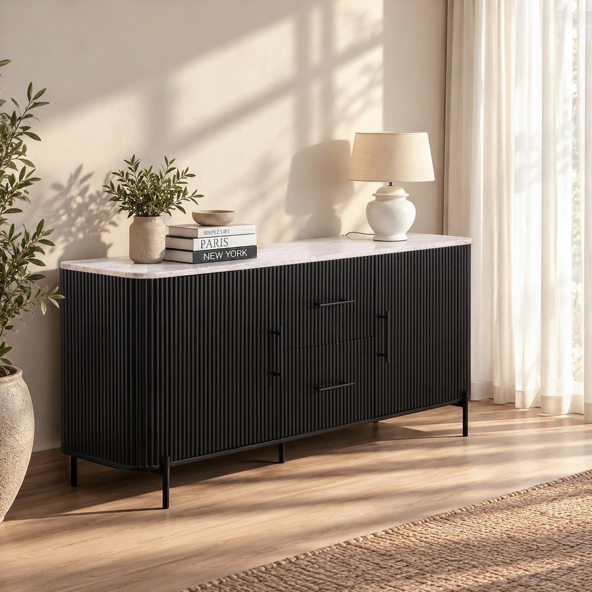 Kelby black buffet with natural marble top, styled in a sunlit room