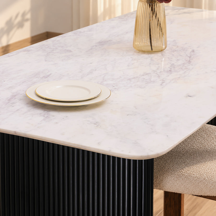 Close-up of the Kelby dining table marble top corner and black reeded base