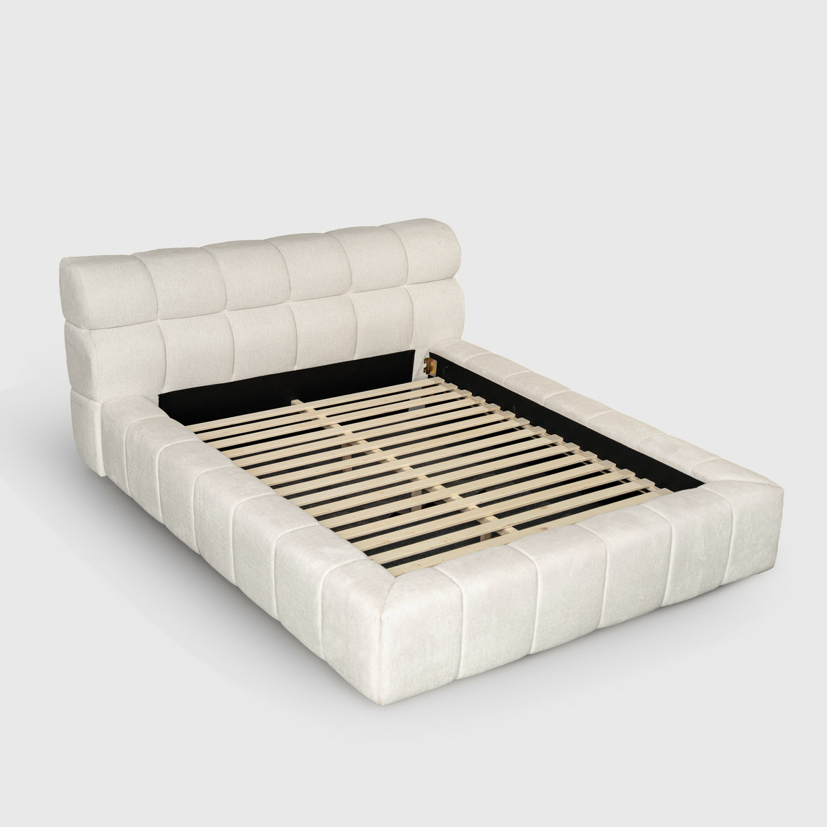 Marshmallow Cloud Bed in ivory fabric, three-quarter view showing tufted headboard and channel-padded frame